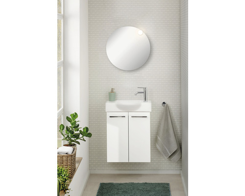 Modernes Badezimmer mit Waschbeckenunterschrank, rundem Spiegel und Zimmerpflanze