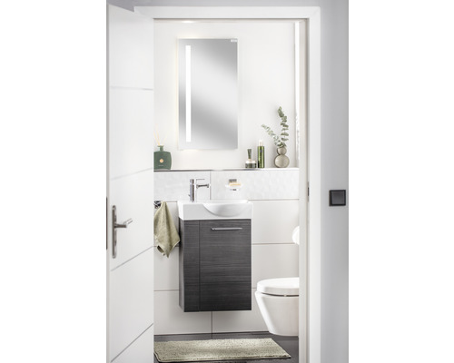 Helles Badezimmer mit Waschtisch, Spiegel mit Beleuchtung und Toilette