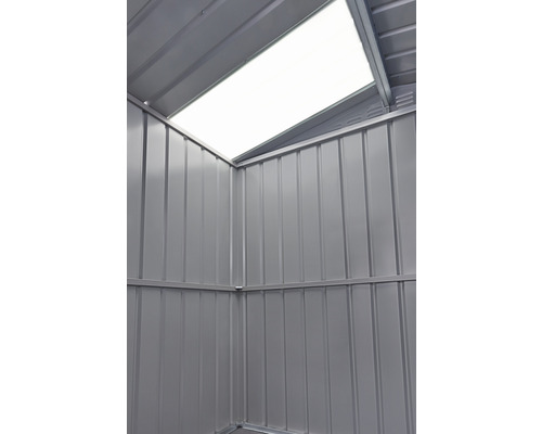 Vue intérieure d''un abri de jardin avec fenêtre de toit et panneaux muraux