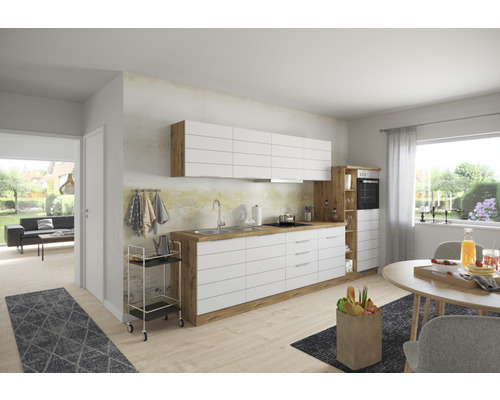 Cuisine lumineuse avec armoires blanches et plan de travail en bois, table à manger et salon en arrière-plan