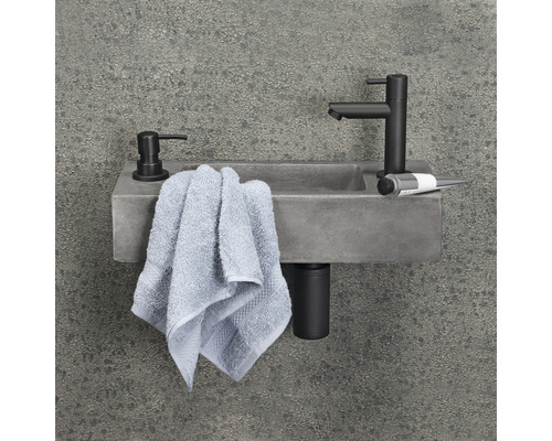 Badezimmer Waschbecken aus Beton mit Armatur, Seifenspender und Handtuch