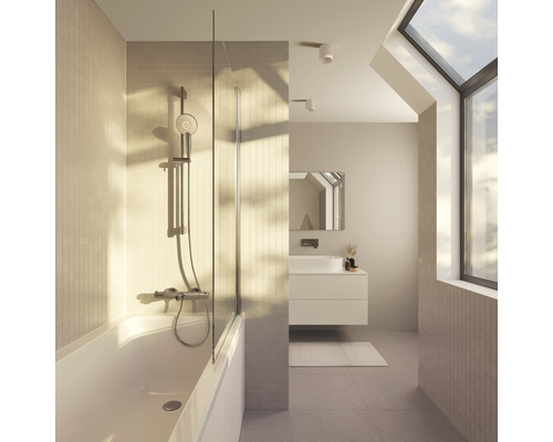 Salle de bain lumineuse avec baignoire, paroi de douche en verre et fenêtre de toit