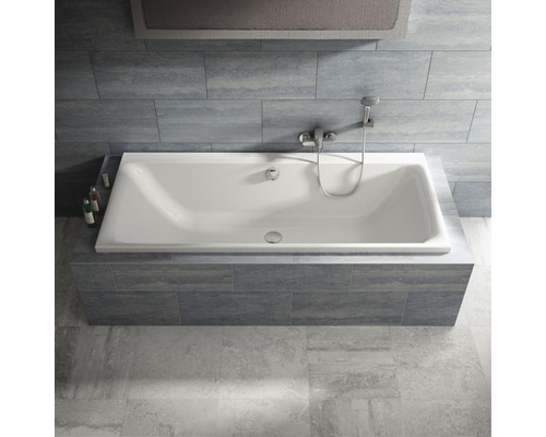 Rechteckige Badewanne mit Armatur und Duschkopf in einem Badezimmer mit Fliesen