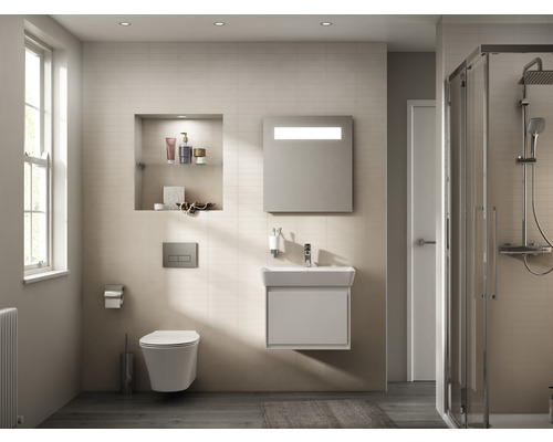 Salle de bain lumineuse avec toilettes, lavabo, armoire de toilette et douche.