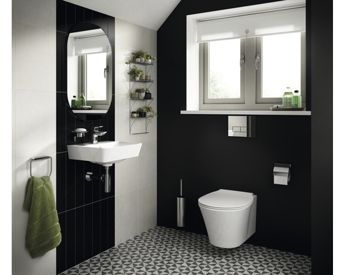 Helles Badezimmer mit Waschbecken, Spiegel, Toilette und geometrischem Bodenmuster