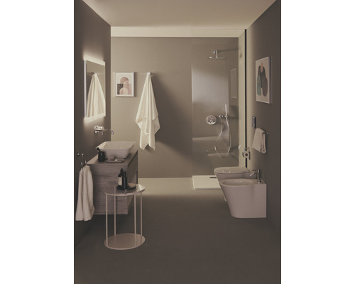 Salle de bains lumineuse avec lavabo, toilettes, bidet et douche