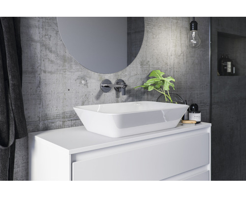 Salle de bain moderne avec vasque à poser, miroir et mur en béton