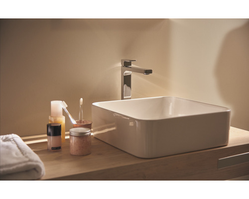 Badezimmerwaschtisch mit Armatur und Pflegeprodukten auf Holzablage