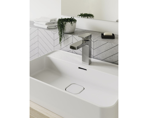 Lavabo de salle de bain moderne avec robinet, plante et serviettes
