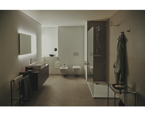 Salle de bain avec lavabo, miroir, douche et toilettes au design lumineux