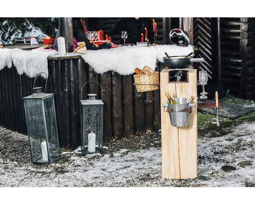 Winterliche Szene mit beleuchteten Laternen und Fondue-Set für eine gemütliche Atmosphäre im Freien