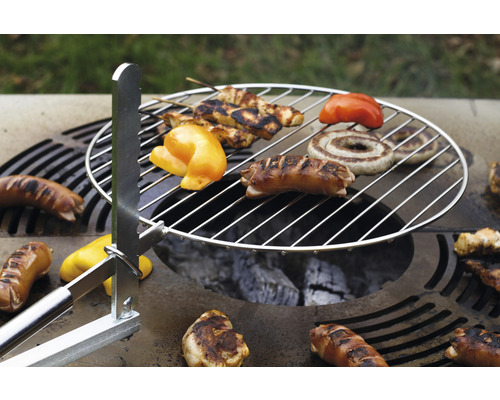 Grillrost mit Grillgut wie Würstchen, Paprika und Fleischspieße über Holzkohle