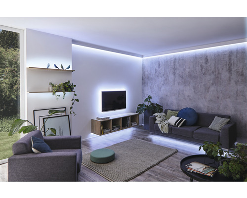 Salon avec canapé, fauteuil, télévision et éclairage indirect.