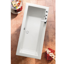 Baignoire rectangulaire dans salle de bain avec robinetterie et décoration
