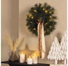 Couronne de Noël décorative avec éclairage, ruban, bougies LED et décoration sur une commode