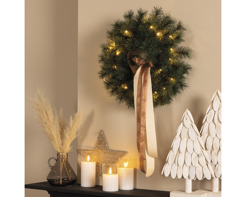 Couronne de Noël décorative avec éclairage, ruban, bougies LED et décoration sur une commode