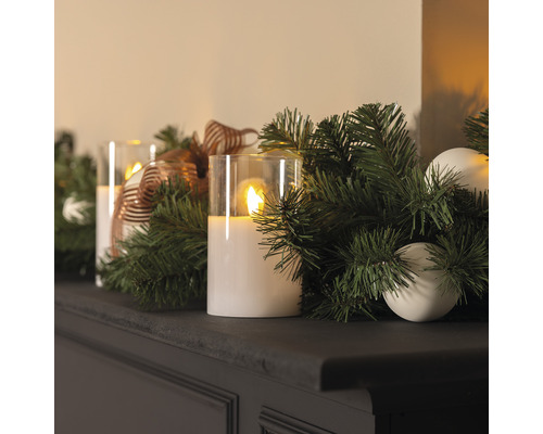 Arrangement décoratif avec bougies LED, branches de sapin et boules de Noël sur une étagère