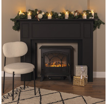 Cheminée décorative avec décoration, cadeaux, fauteuil et tapis dans un salon