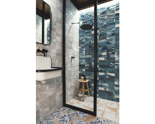 Salle de bains avec douche, lavabo et carrelage de différentes couleurs