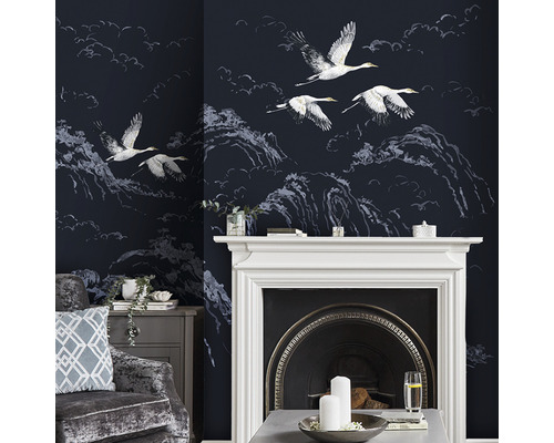 Salon décoratif avec papier peint représentant des grues et des paysages de montagne.