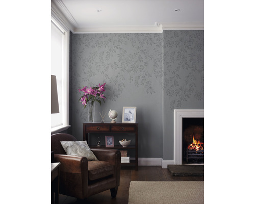 Wohnzimmer mit Sessel, Kamin und dekorativer Tapete