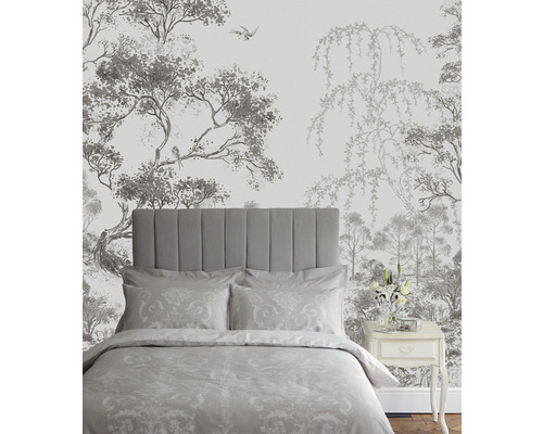 Chambre avec lit devant un papier peint avec des motifs d''arbres et d''oiseaux.