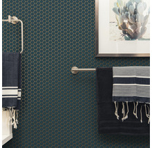 Mur de salle de bain avec des carreaux de mosaïque hexagonaux, des porte-serviettes et des serviettes