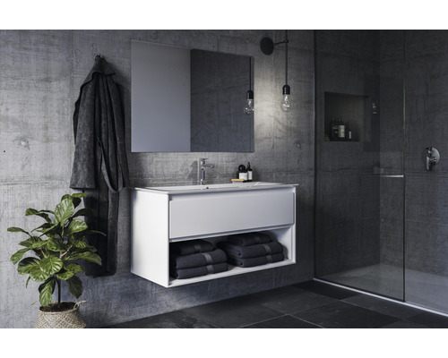 Salle de bains moderne avec meuble sous-lavabo, miroir, serviettes et plante