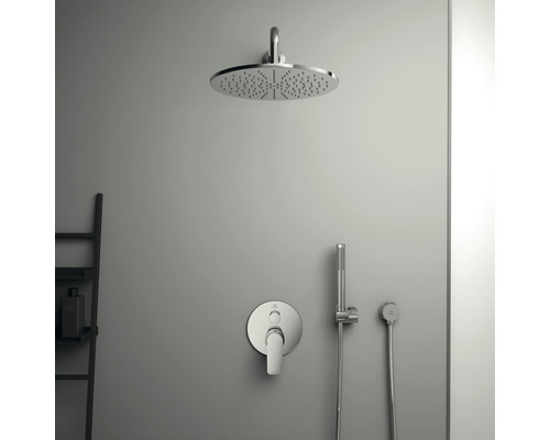 Duschkopf mit Armatur und Handbrause an einer grauen Wand