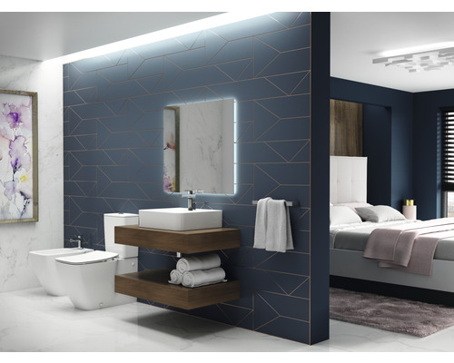 Salle de bains avec toilettes, bidet, lavabo, miroir et chambre avec lit en arrière-plan