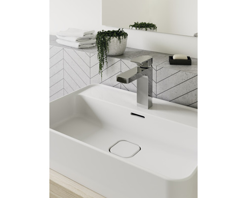 Lavabo de salle de bain avec robinet, savon, serviettes et plante