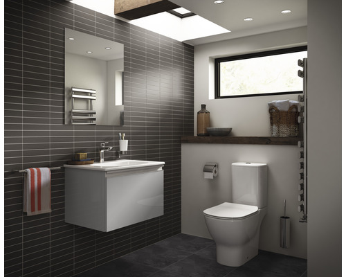 Salle de bain moderne avec WC, meuble sous-lavabo, miroir et sèche-serviettes.