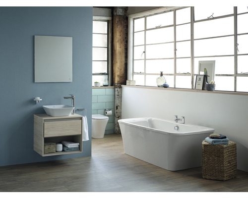 Salle de bains avec meuble-lavabo, miroir, baignoire et toilettes dans un design clair et spacieux