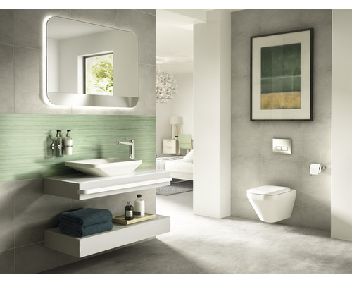 Salle de bains moderne avec lavabo, miroir avec éclairage et WC suspendu.
