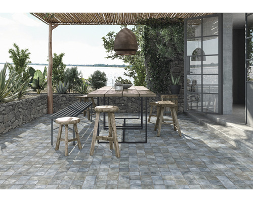 Espace extérieur avec carrelage au sol, table en bois et sièges sous une pergola