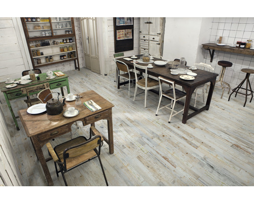 Heller Raum mit Holzboden, mehreren Tischen und Stühlen in unterschiedlichem Design.