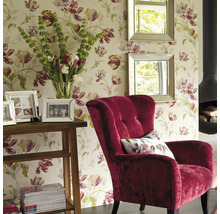 Salon avec papier peint fleuri, fauteuil, miroirs, table et cheminée