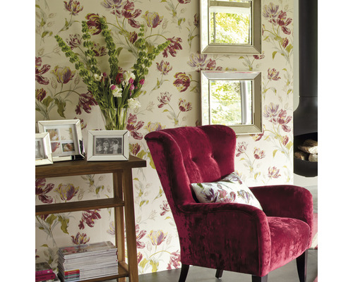 Wohnzimmer mit Blumentapete, Sessel, Spiegeln, Tisch und Kamin