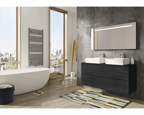 Badezimmer mit Badewanne, Waschtisch, Spiegel, Heizkörper und Teppich in hellem und geräumigem Design