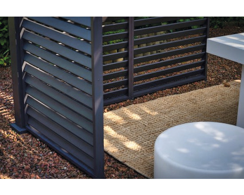 Gros plan d''un écran d''intimité moderne avec des lamelles horizontales dans un jardin.