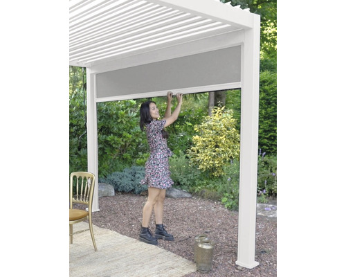 Femme manipule une pergola avec protection solaire coulissante pour le jardin.