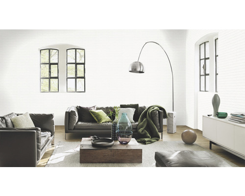 Helles Wohnzimmer mit Ledersofa und gemusterter Tapete in Steinoptik