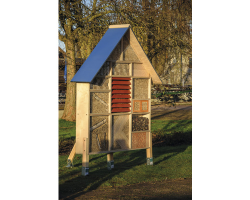 Hôtel à insectes en bois avec différents matériaux de remplissage dans le jardin