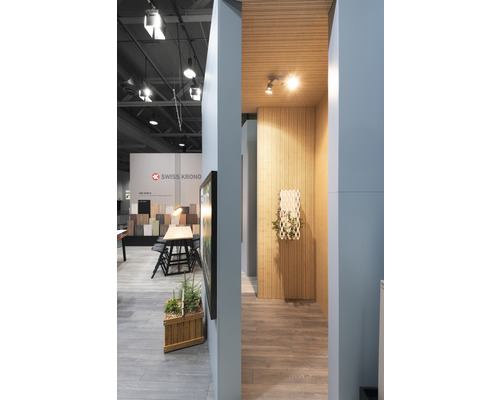 Aménagement intérieur avec plancher en bois, panneaux muraux en bois et logo Swiss Krono