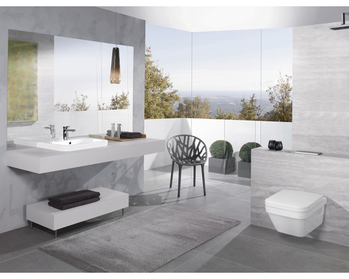 Salle de bains moderne avec lavabo, miroir, toilettes et chaise