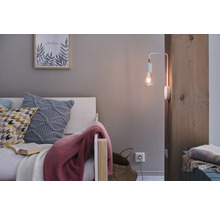 Chambre confortable avec lit, coussins, couverture et applique murale