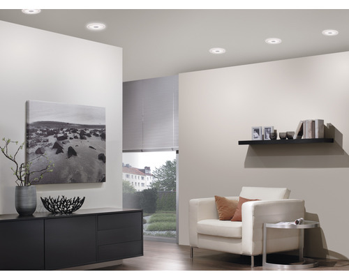 Salon avec plafonniers, fauteuil et buffet