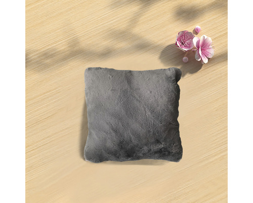 Coussin gris sur une table en bois avec des fleurs