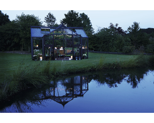 Gewächshaus mit Esstisch und Beleuchtung im Garten