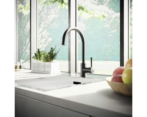 Évier de cuisine avec robinet devant une fenêtre